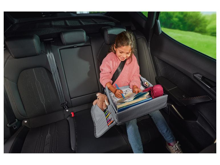 Un enfant utilise un organisateur de voiture dans la voiture.