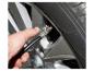 Une main connectant une pompe à air à un pneu de voiture.