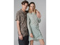 Un homme et une femme portent des vêtements décontractés : il porte une chemise à motifs et elle une robe vert clair.