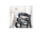 Chaise haute en bois noir avec plateau et harnais, à côté d'une table blanche avec vaisselle pour enfants.
