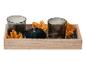 Plateau décoratif automnal avec deux bougeoirs en verre foncé, une citrouille en velours et des feuilles.