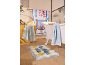 Salle de bain avec tapis de bain à carreaux, serviettes rayées et rideau de douche à motif de poisson.