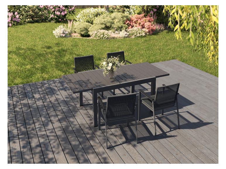 Ensemble de salle à manger d'extérieur avec table et six chaises sur une terrasse avec jardin.