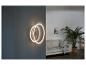 Un luminaire mural moderne avec deux anneaux dans un salon.