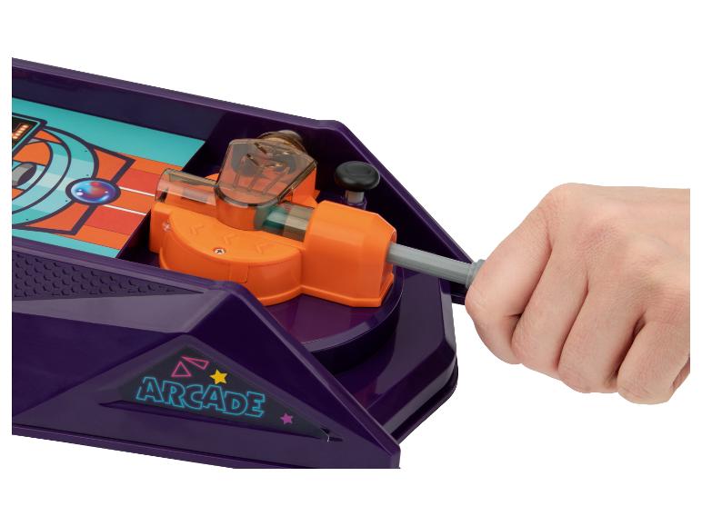 Une main actionnant un jeu de société violet avec un levier orange