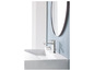 Un lavabo avec un robinet chromé et un miroir rond.