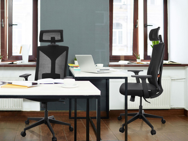 Deux chaises de bureau noires avec appuie-tête dans un bureau.