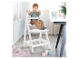 Une chaise haute blanche Roba pour bébé, avec un jeune enfant assis dessus.