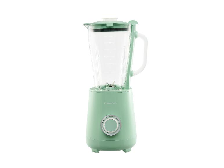 Mixeur vert clair avec un pichet en verre et un bouton argenté.