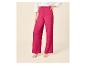 Pantalon fuchsia texturé à jambes larges pour femme, associé à une chemise blanche et des sandales à talons.