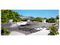 Une chaise longue grise avec un auvent sur une terrasse.
