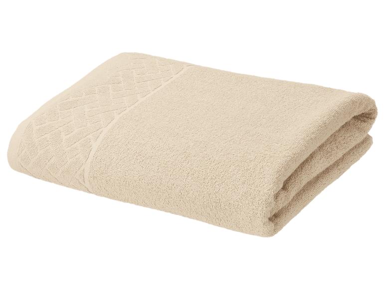 Serviette en coton beige pliée avec un motif décoratif