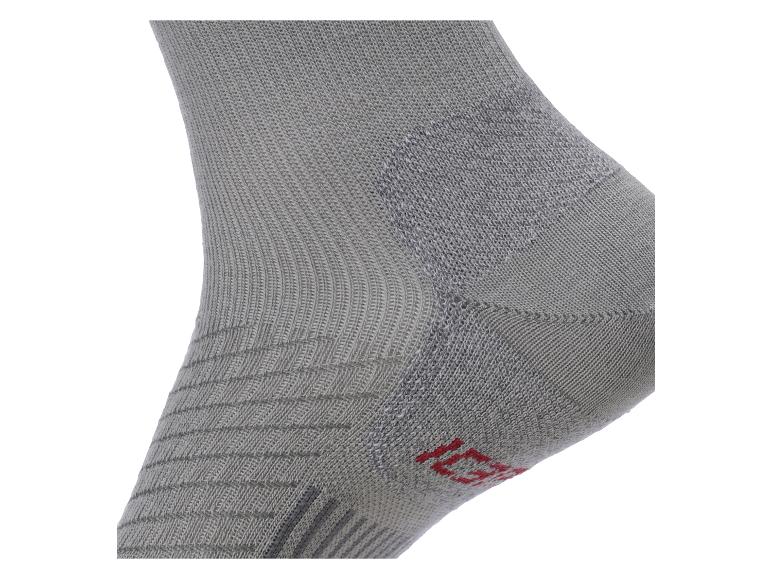Gros plan d'une chaussette grise avec des motifs texturés et un détail rouge.