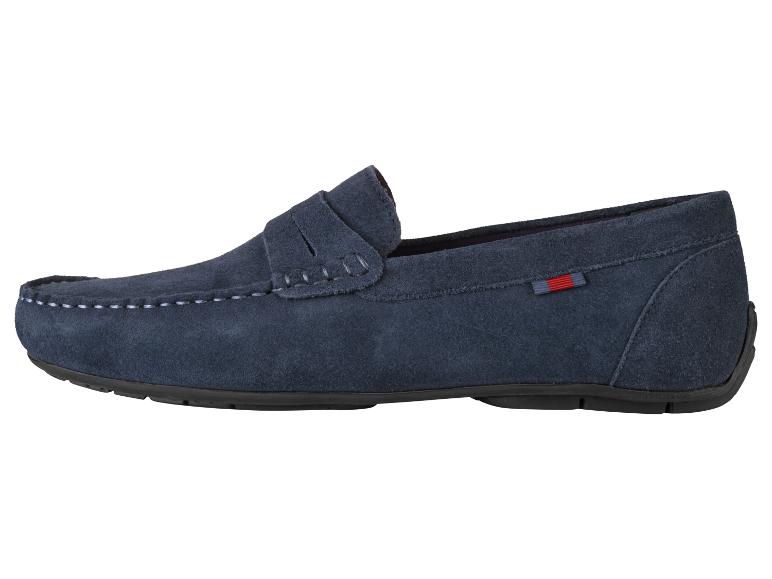 Un mocassin en daim bleu marine avec une étiquette rouge et blanche.