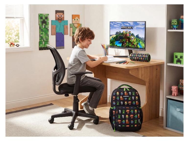 Garçon dessinant à un bureau en bois avec un sac à dos et une déco jeu vidéo.