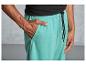Un homme porte un pantalon de survêtement turquoise avec un cordon noir.