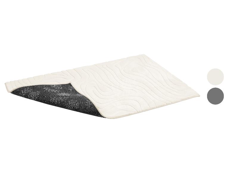 Tapis de bain beige avec gaufrage grain de bois et envers antidérapant à motif floral.