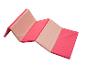 Un tapis pliable rose et beige pour le fitness et le yoga.