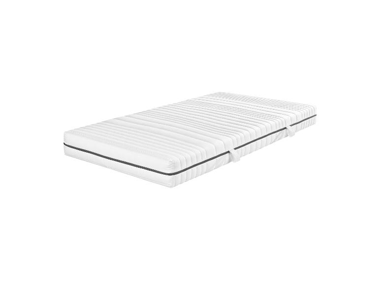 Un matelas blanc avec capitonnage rayé.