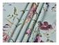 Tissu bleu clair avec un motif floral de fleurs violettes et roses et de feuilles vertes.