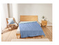 Un lit avec une couette bleue dans une chambre à coucher