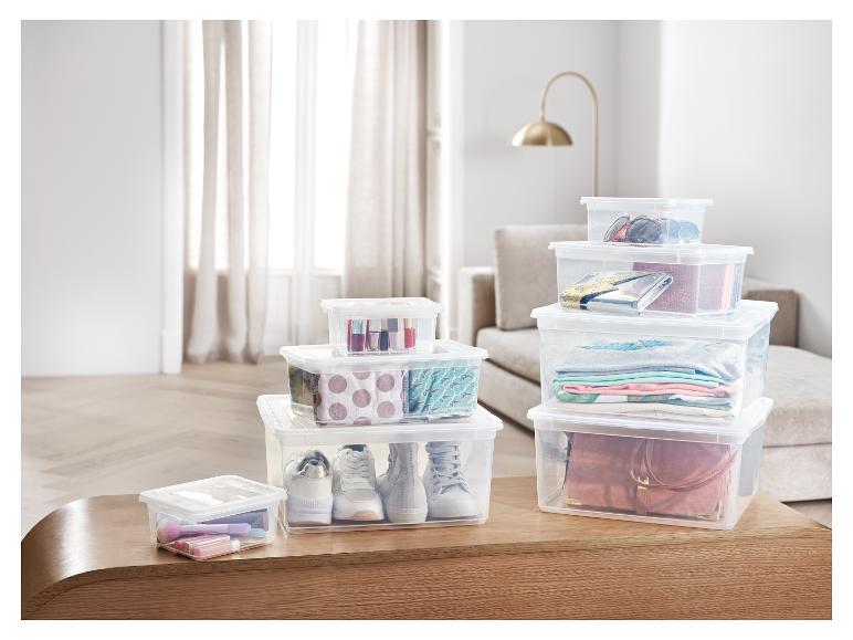 Boîtes de rangement transparentes avec des vêtements, des chaussures et du maquillage.