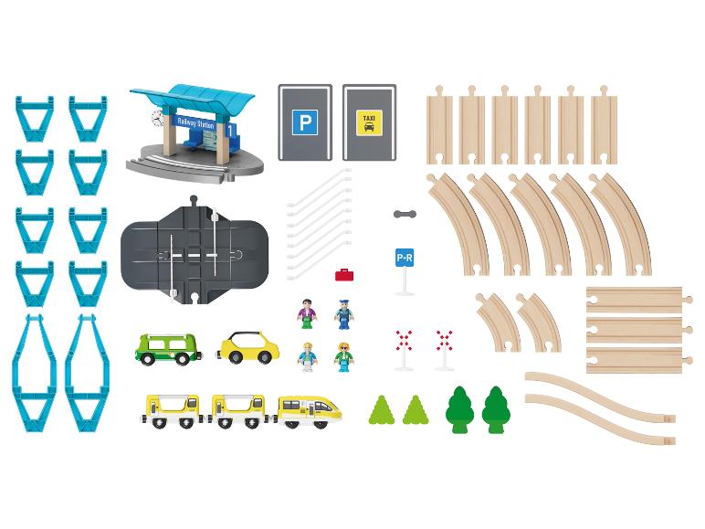 Ensemble de train en bois avec locomotive, wagons, rails, arbres et figurines.