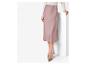 Une femme porte une jupe en satin rose et des talons hauts.