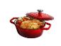 Cocotte en fonte rouge avec poulet rôti et légumes, couvercle entrouvert