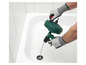 Une personne utilise un déboucheur Parkside pour déboucher un drain bouché dans une baignoire.