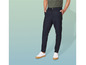 Un homme portant un pantalon bleu marine et des baskets blanches.