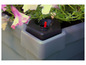 Une jardinière grise avec un réservoir d'eau et une connexion d'eau rouge.