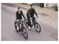 Couple roulant des vélos électriques sur une route de ville.