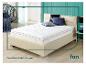 Un matelas blanc avec une tête de lit beige, sur un fond turquoise.