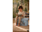Enfant lisant un livre assis sur un banc de rangement thème forêt.