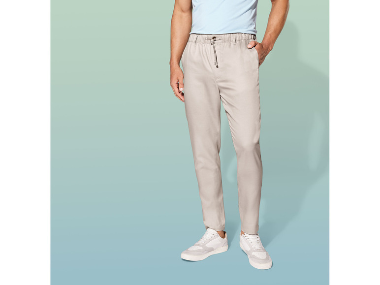 Pantalon beige avec taille élastique et baskets blanches.