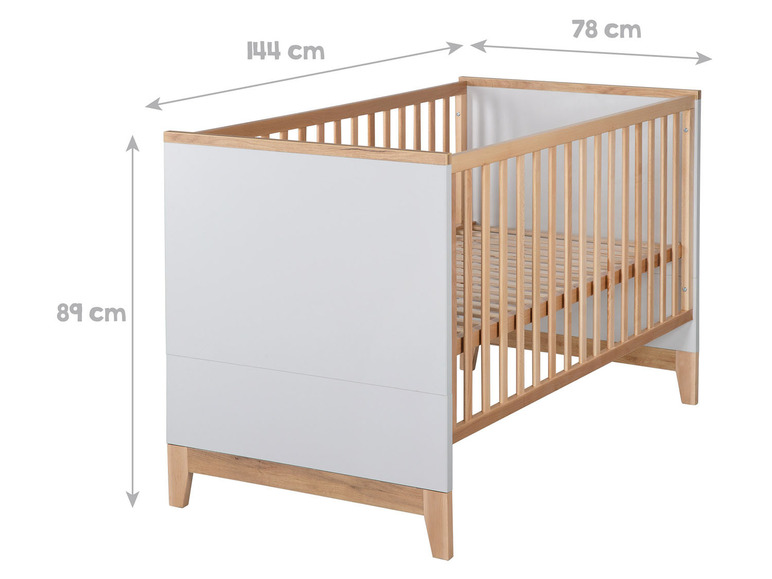 Un lit bébé blanc avec des lattes et des pieds en bois.