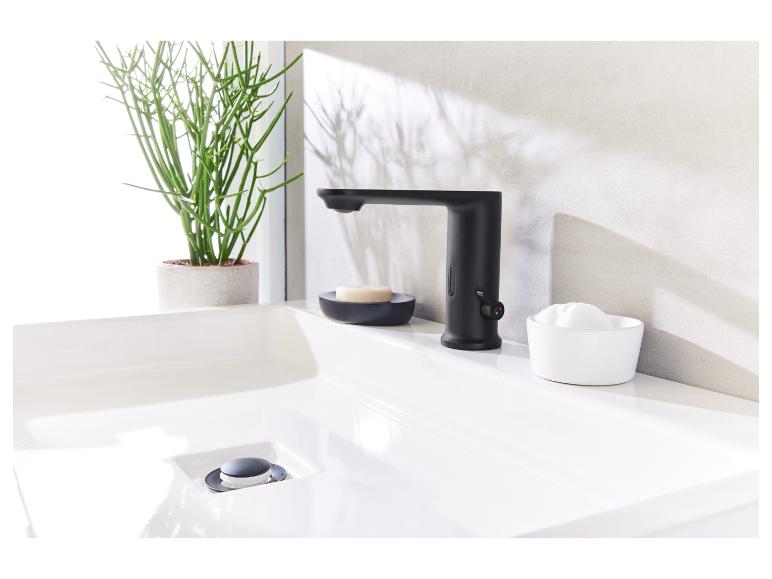 Robinet noir, lavabo et accessoires de salle de bain design.