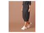 Une femme portant une jupe grise et des baskets blanches.