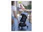 Une poussette grise avec un siège bleu foncé, adaptée à un enfant.