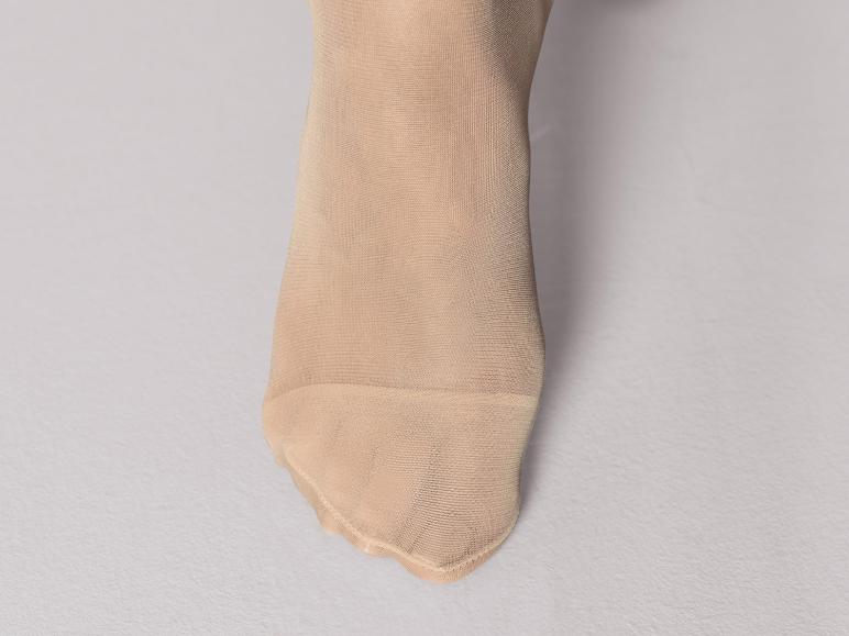 Une paire de collants beiges, visibles à partir de la cheville.