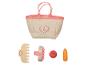 Un sac rose avec un motif de cheval, une brosse en bois, un peigne et des jouets en forme de fruits et légumes.