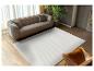 Tapis blanc à motif ondulé dans un salon moderne avec canapé et fauteuil en cuir.