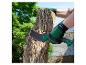 Une personne portant des gants Parkside utilise une machette Parkside pour couper un arbre.