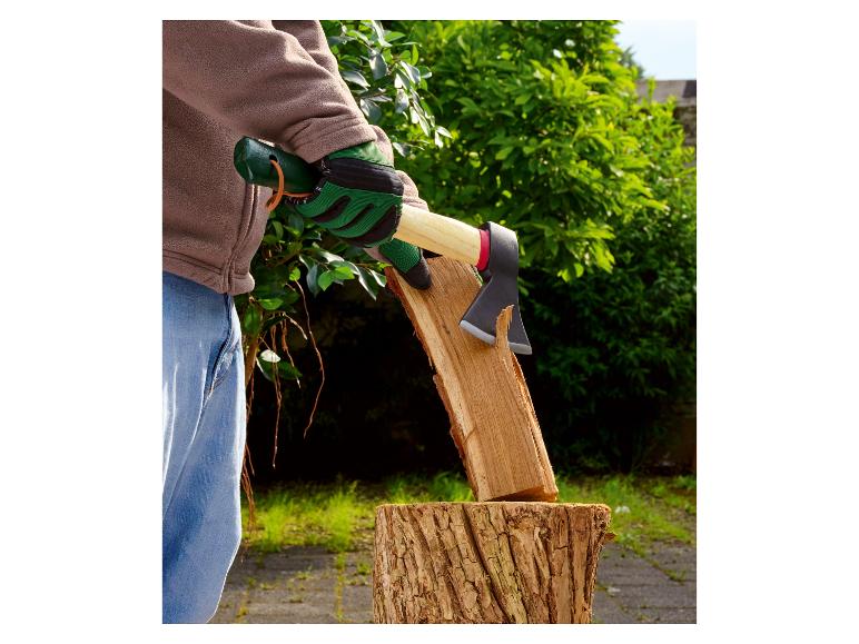 Une personne fend du bois avec une hache, portant des gants de travail.