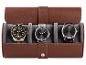 Trois montres-bracelets élégantes dans un étui de rangement marron clair.