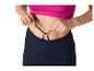 Femme ajustant les lacets d'un legging de sport et d'un haut rose.