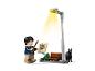 Figurine LEGO Harry Potter avec baguette, journal et un chien noir sous un lampadaire.