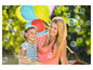 Une mère et sa fille rient en jouant avec des ballons et des bulles de savon en plein air.