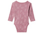 Un body bébé rose avec un motif de moutons blancs.